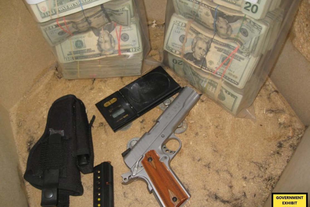 Photo of bags of cash, a gun and a scale