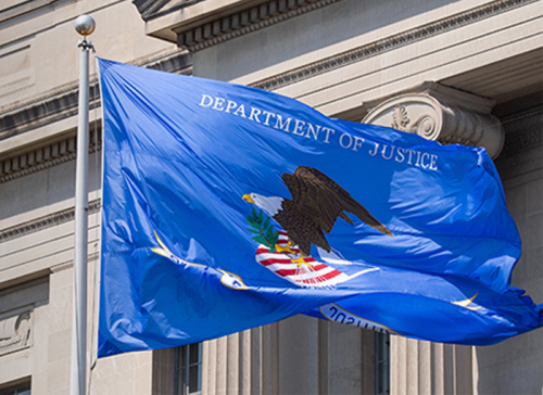 Department of Justice flag in front of DOJ building